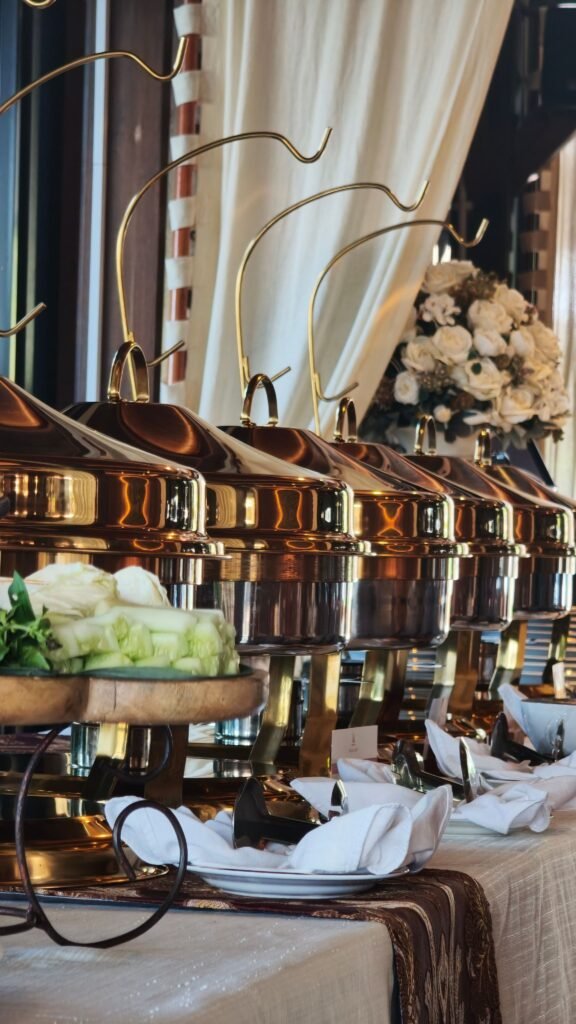 Luxurious indoor buffet setup featuring golden chafing dishes and elegant decor.